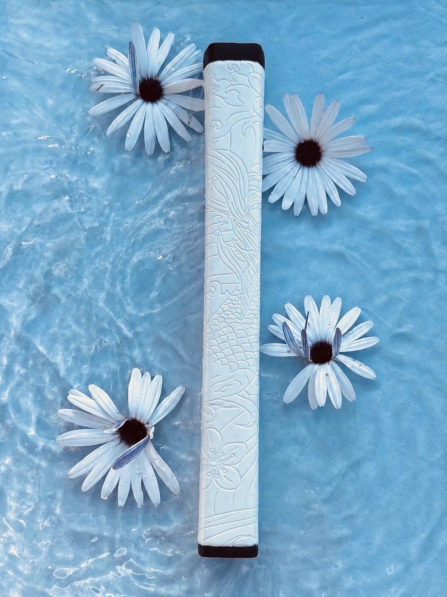 Kaiyen Japanese art-inspired putter grip floating in water with white daisies